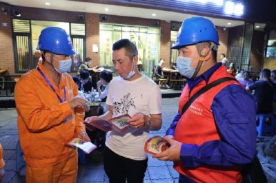 為各個攤位檢查用電安全情況、排查隱患、發(fā)放用電安全宣傳單